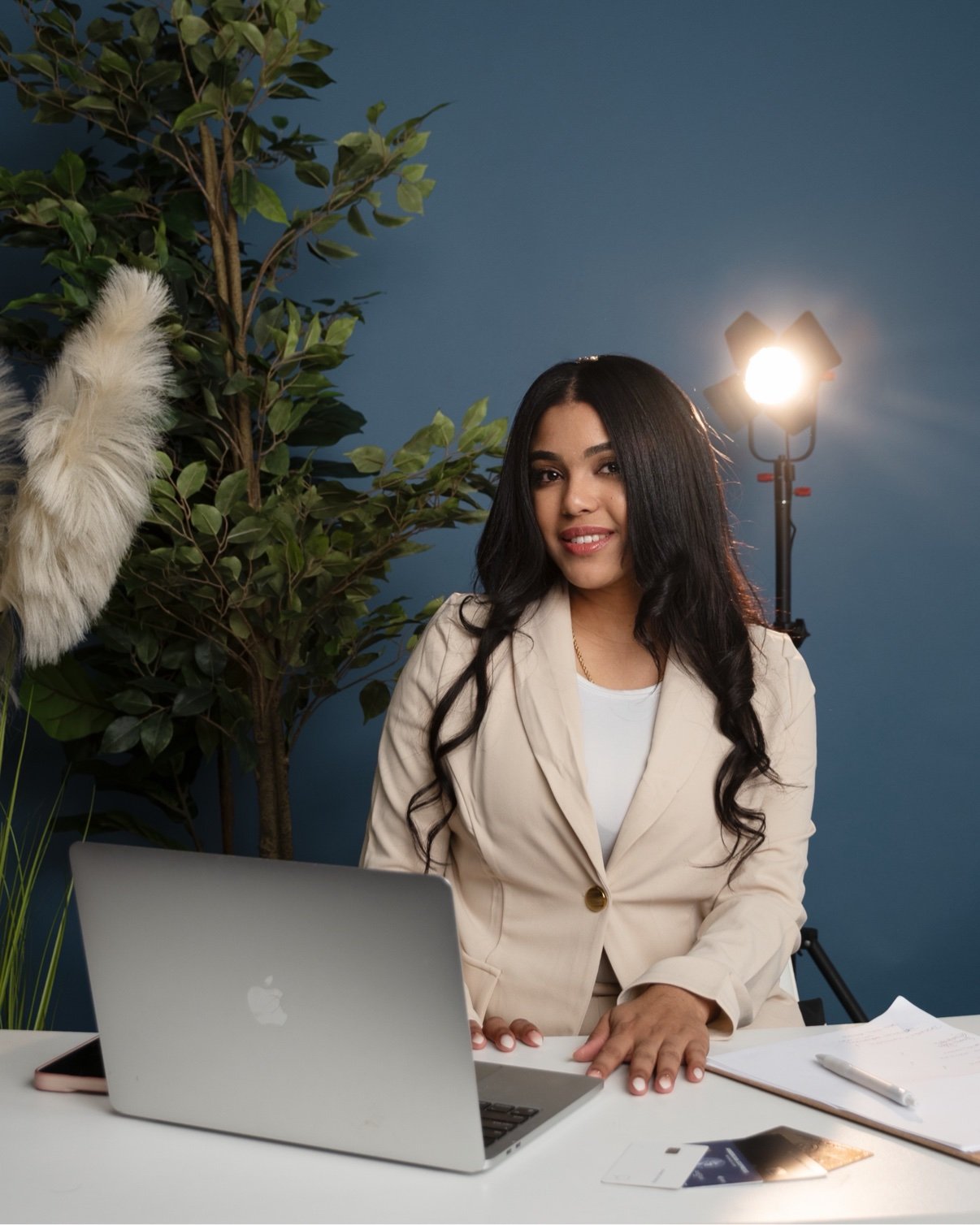 Keyla Acevedo con traje beige y laptop